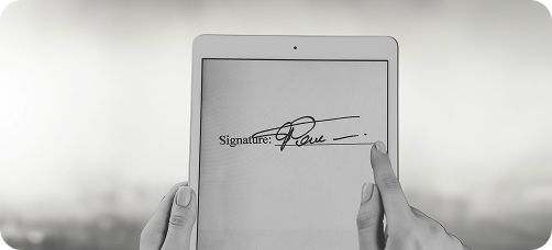 Persoon zet digitale handtekening op tablet als onderdeel van juridisch document bij The Law Firm.